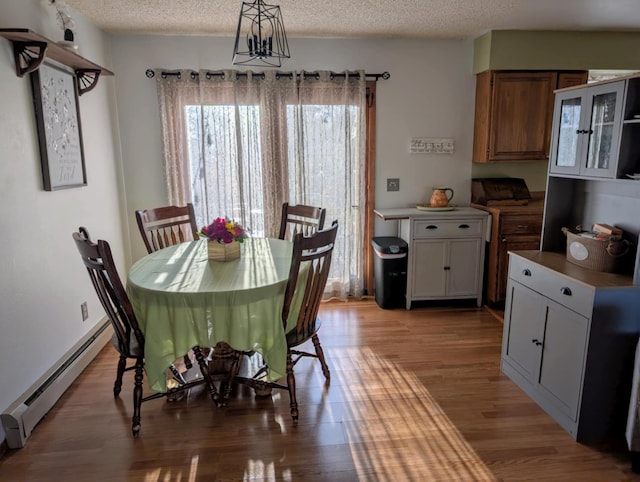 2599 Pike Dr, East Helena, MT 59635 - dining room with a textured ceiling, light wood-style floors, and baseboard heating
