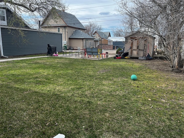view of yard featuring a patio, an outbuilding, and a storage unit