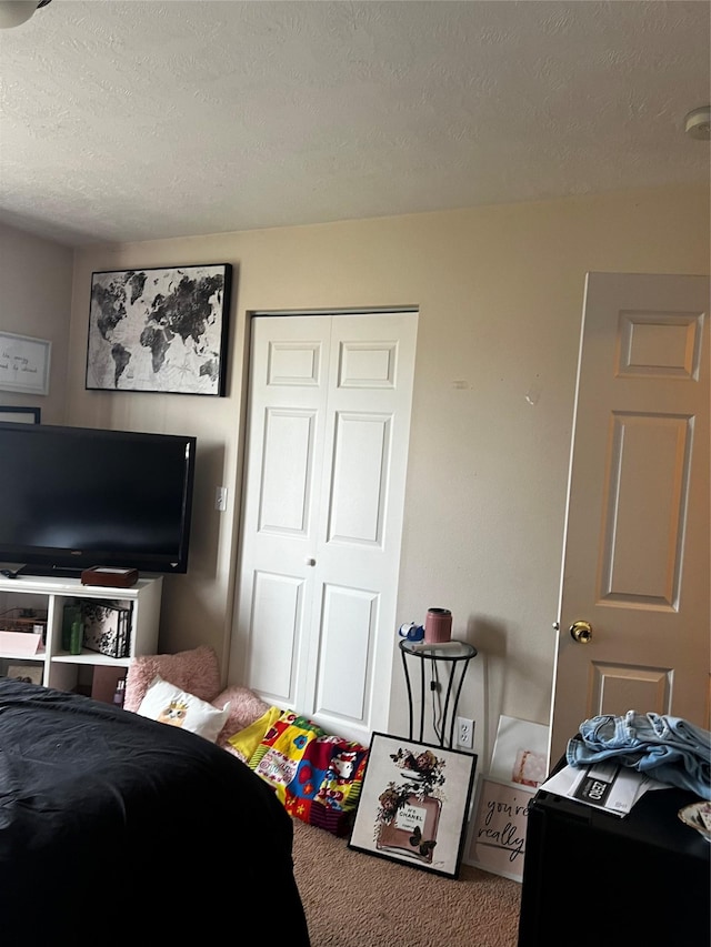 bedroom featuring a closet, carpet, and a textured ceiling