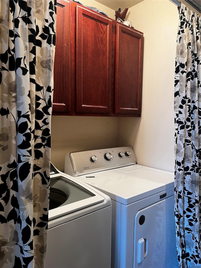 clothes washing area with cabinet space and independent washer and dryer