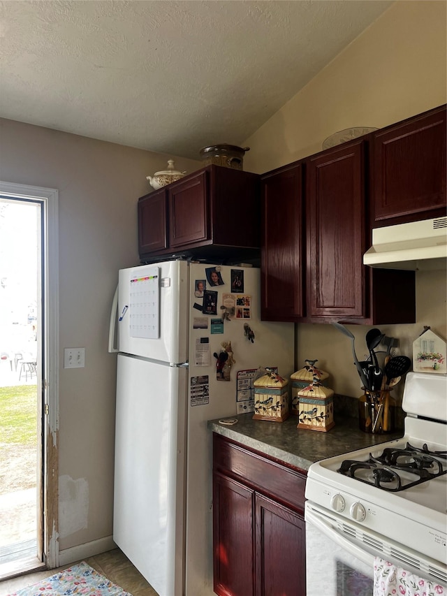 kitchen featuring reddish brown cabinets, white appliances, and under cabinet range hood