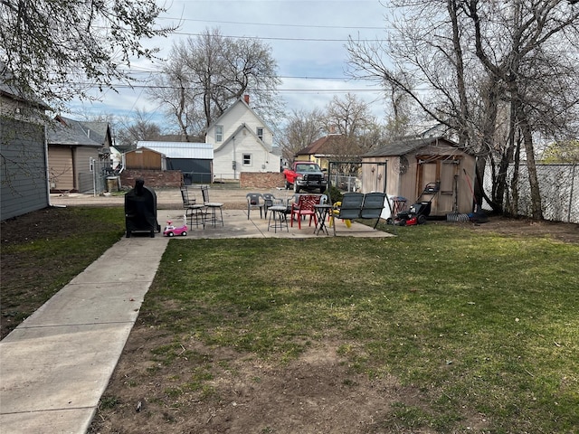 view of yard with a patio, a shed, fence, and an outdoor structure