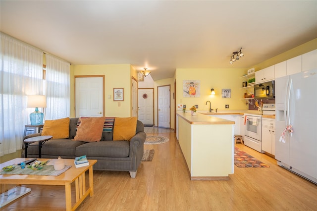 701 N Davis St Unit A, Helena, MT 59601 - kitchen with white appliances, light wood-type flooring, a peninsula, and white cabinetry