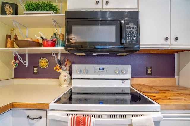701 N Davis St Unit A, Helena, MT 59601 - kitchen with white electric range oven, black microwave, and white cabinetry
