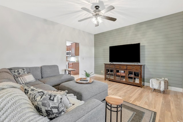 15022 Romulus Ln, Frenchtown, MT 59834 - living area featuring baseboards, light wood-style flooring, a ceiling fan, and wood walls