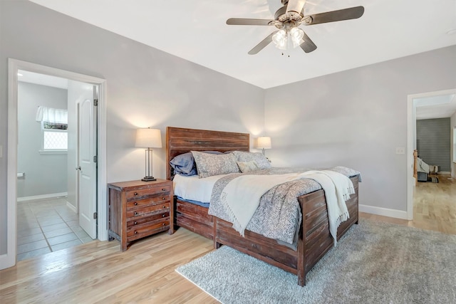 15022 Romulus Ln, Frenchtown, MT 59834 - bedroom featuring baseboards, wood finished floors, ensuite bathroom, and ceiling fan
