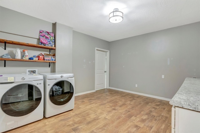 15022 Romulus Ln, Frenchtown, MT 59834 - washroom with light wood-style flooring, separate washer and dryer, baseboards, and cabinet space