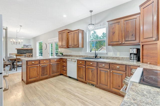 15022 Romulus Ln, Frenchtown, MT 59834 - kitchen featuring white dishwasher, a sink, a chandelier, a peninsula, and brown cabinets