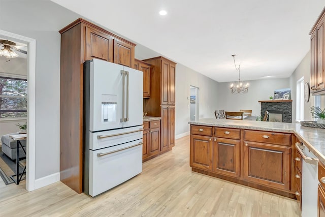 15022 Romulus Ln, Frenchtown, MT 59834 - kitchen featuring white appliances, light wood-type flooring, baseboards, a chandelier, and a peninsula