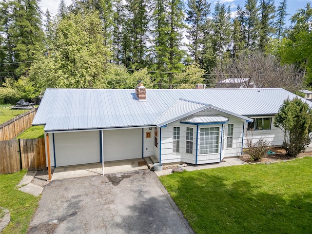 139 Highwood Dr, Libby, MT 59923 - ranch-style house featuring metal roof, asphalt driveway, a chimney, and an attached garage
