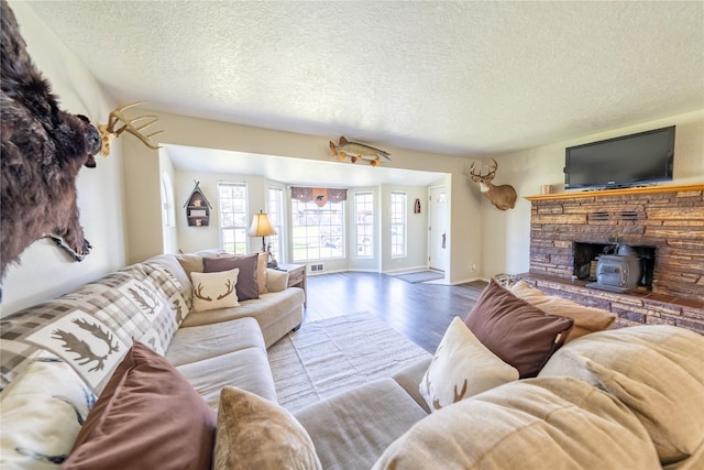 139 Highwood Dr, Libby, MT 59923 - living area featuring wood finished floors, a textured ceiling, a wood stove, and baseboards