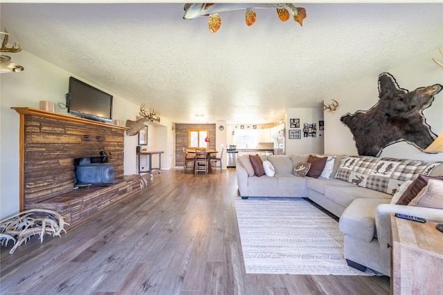 139 Highwood Dr, Libby, MT 59923 - living room featuring a textured ceiling, a wood stove, and wood finished floors