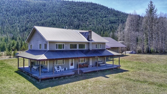 2 Trails End Dr, Heron, MT 59844 - back of house featuring a forest view, a chimney, a yard, and metal roof