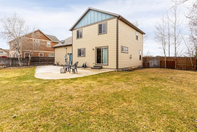 1101 E Gallatin Ave, Belgrade, MT 59714 - back of property featuring board and batten siding, a patio area, a fenced backyard, and a yard