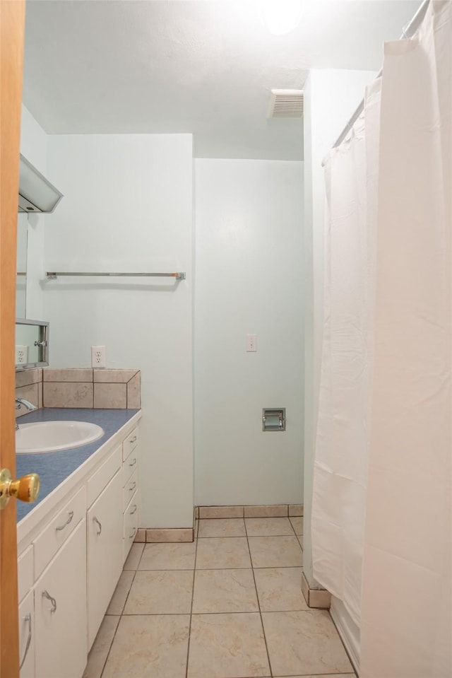 full bath with tile patterned floors, vanity, baseboards, and visible vents