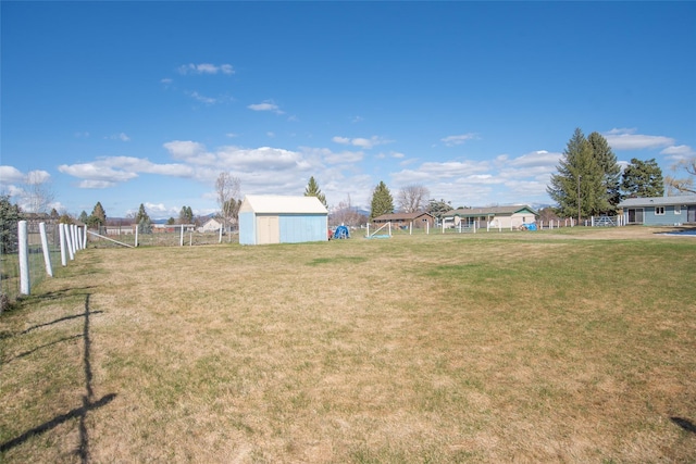 view of yard with fence and an outdoor structure