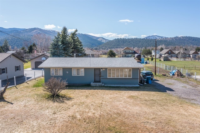 ranch-style house with a mountain view, a front yard, and fence
