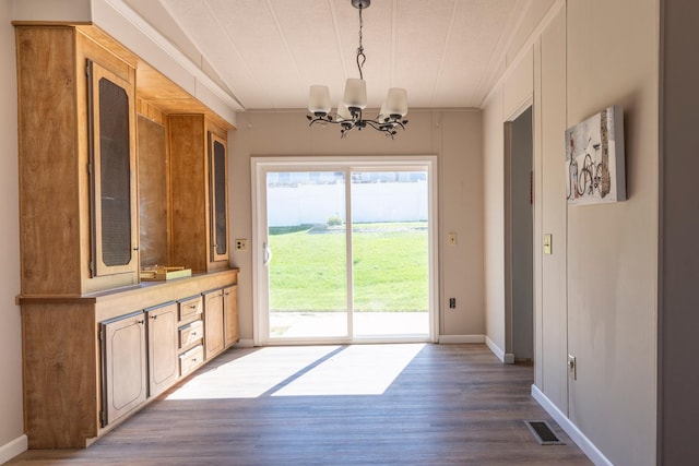 714 Rosalind St, Philipsburg, MT 59858 - unfurnished dining area with a chandelier, dark wood-style flooring, baseboards, and ornamental molding