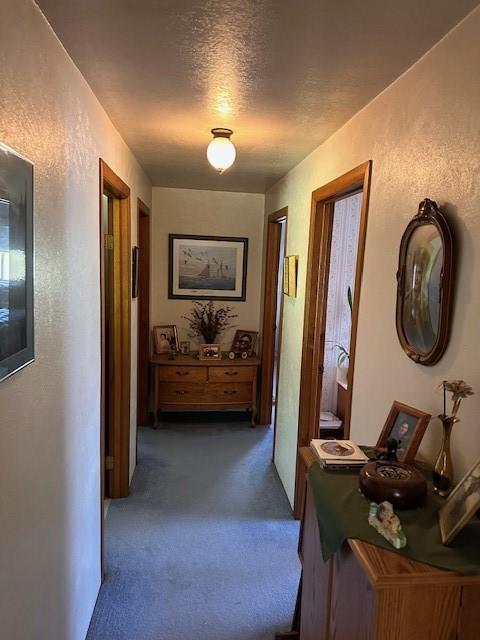 708 Johnson Ln, Superior, MT 59872 - corridor featuring dark carpet, a textured ceiling, and a textured wall