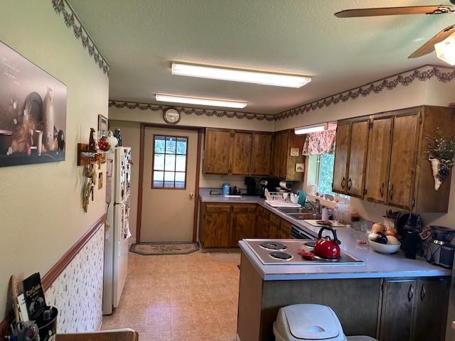 708 Johnson Ln, Superior, MT 59872 - kitchen featuring a ceiling fan, a sink, freestanding refrigerator, a peninsula, and light floors