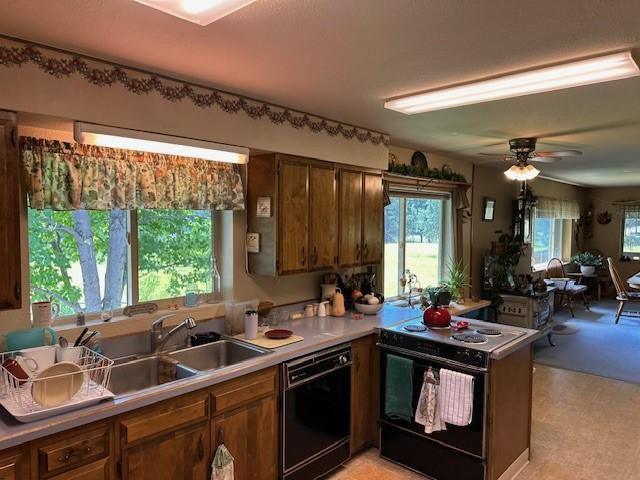 708 Johnson Ln, Superior, MT 59872 - kitchen with a sink, a peninsula, light countertops, a ceiling fan, and black appliances