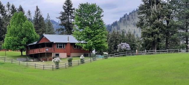708 Johnson Ln, Superior, MT 59872 - rear view of house featuring a lawn, fence, a deck with mountain view, and a rural view