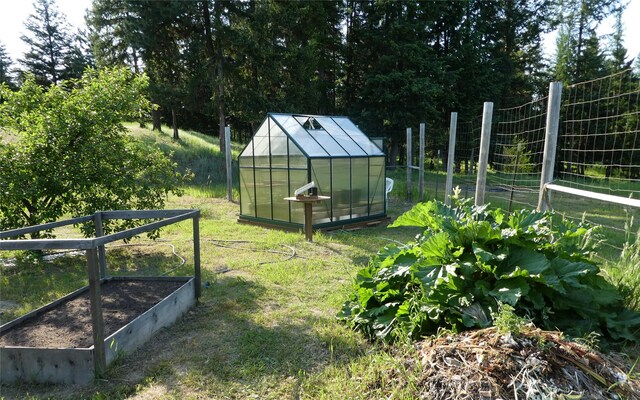 708 Johnson Ln, Superior, MT 59872 - view of yard featuring a greenhouse, an outdoor structure, and a vegetable garden