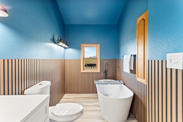 32306 St Ignatius Airport Rd, Saint Ignatius, MT 59865 - bathroom with a freestanding bath, wainscoting, wood finished floors, and vanity