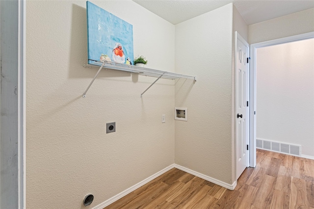 washroom with visible vents, baseboards, hookup for a washing machine, and light wood-style floors