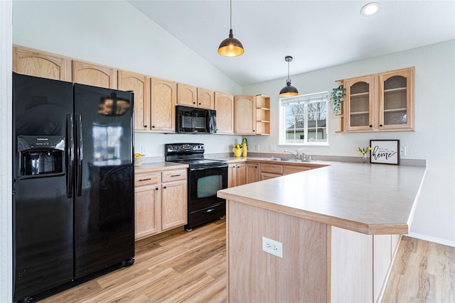 kitchen featuring glass insert cabinets, a peninsula, light brown cabinetry, black appliances, and a sink