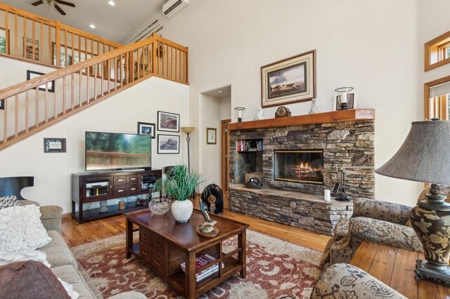 196 Pine Needle Ln, Bigfork, MT 59911 - living area with wood finished floors, a wall mounted air conditioner, a high ceiling, stairway, and a ceiling fan