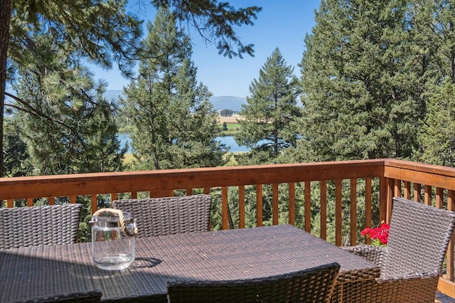 196 Pine Needle Ln, Bigfork, MT 59911 - wooden terrace with outdoor dining area and a mountain view