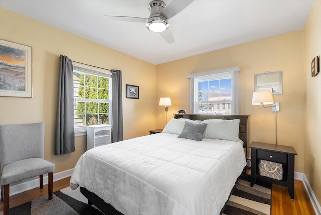 bedroom with ceiling fan, baseboards, and wood finished floors