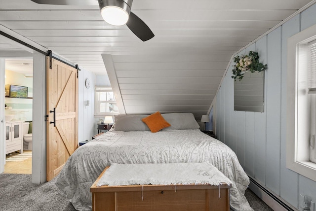 bedroom with carpet flooring, a barn door, ensuite bathroom, baseboard heating, and a ceiling fan