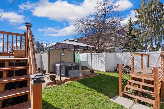 view of yard with a fenced backyard, a gazebo, a wooden deck, a hot tub, and stairs