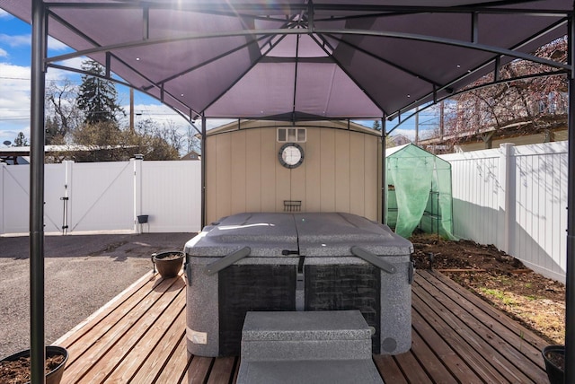 wooden deck with a fenced backyard, a gate, and outdoor dining space