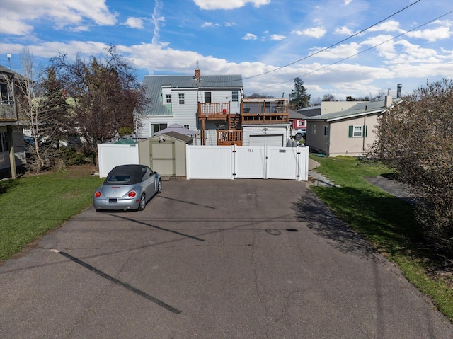 view of front of property featuring fence, a front lawn, a gate, and metal roof