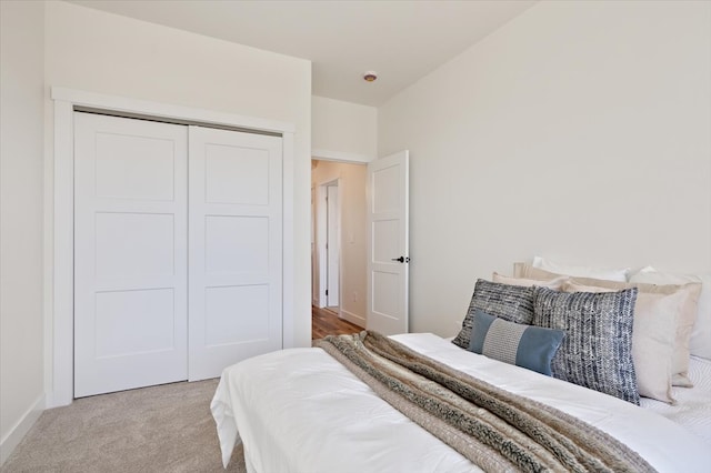 bedroom with baseboards, a closet, and carpet