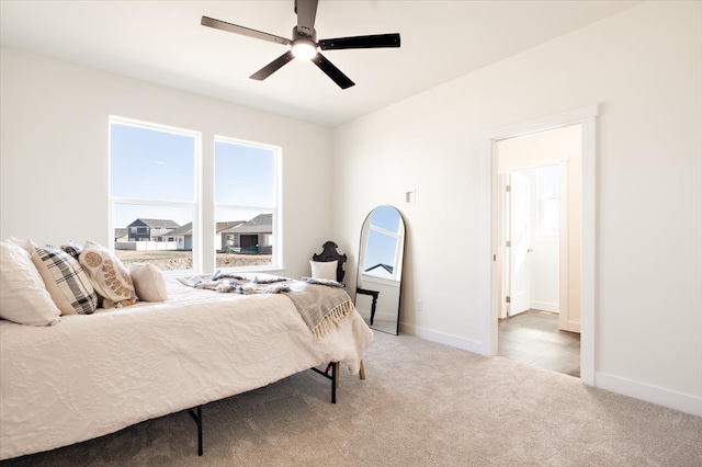 carpeted bedroom with a ceiling fan and baseboards