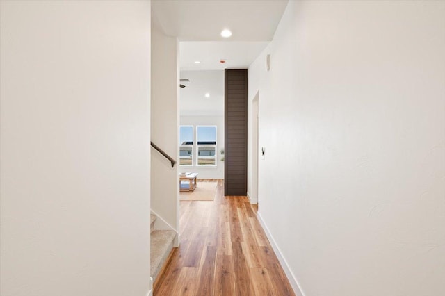 corridor featuring recessed lighting, baseboards, stairway, and light wood-style flooring