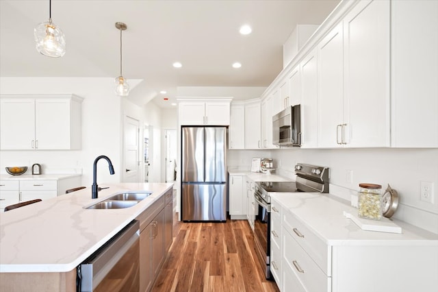 kitchen featuring a sink, hanging light fixtures, light wood finished floors, appliances with stainless steel finishes, and recessed lighting