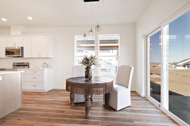 dining area featuring recessed lighting, light wood-style flooring, and baseboards