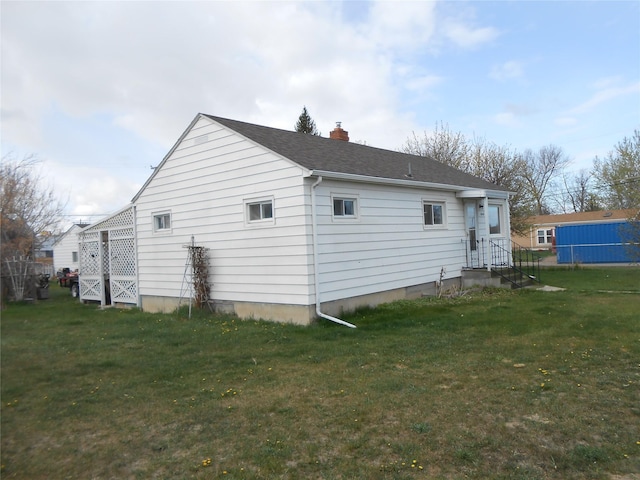 1426 2nd Ave NW, Great Falls, MT 59404 - rear view of house with roof with shingles, a chimney, and a yard