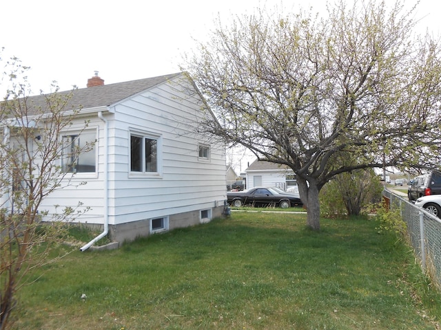 1426 2nd Ave NW, Great Falls, MT 59404 - view of home's exterior featuring roof with shingles, fence, a yard, and a chimney