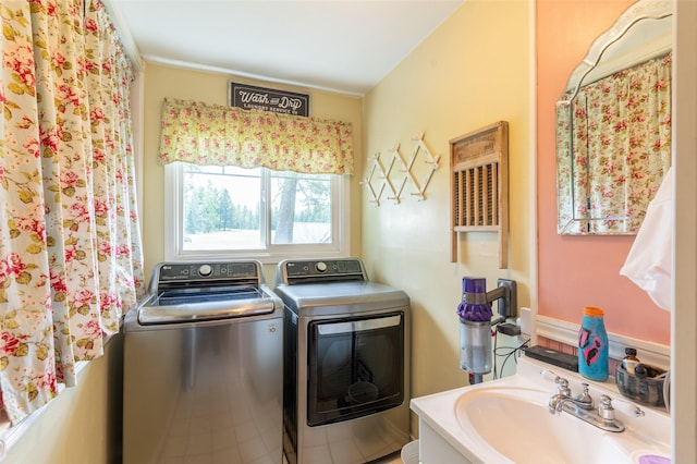 clothes washing area featuring a sink, independent washer and dryer, and laundry area