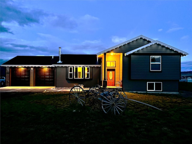 view of front facade featuring a garage, driveway, and a front lawn
