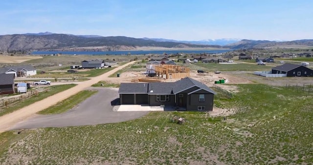 aerial view of property and surrounding area featuring a water and mountain view