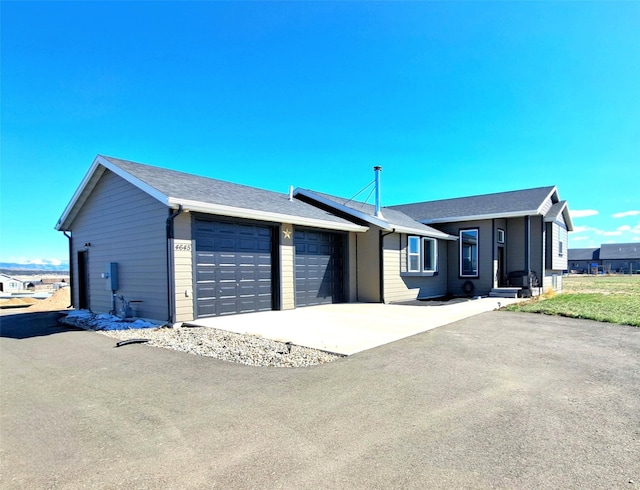 ranch-style house featuring an attached garage and concrete driveway