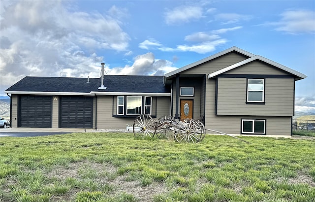 split level home with an attached garage, a front yard, and driveway