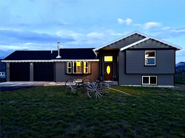 view of front of property with a garage, a front yard, and asphalt driveway